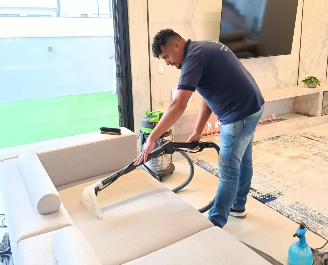 Profissional da MT Higienização realizando a limpeza de um sofá